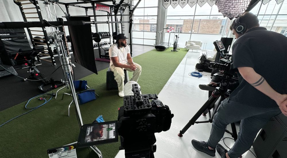 IMG_1181 Behind the scenes of a video shoot at a gym, showing the AV equipment set up