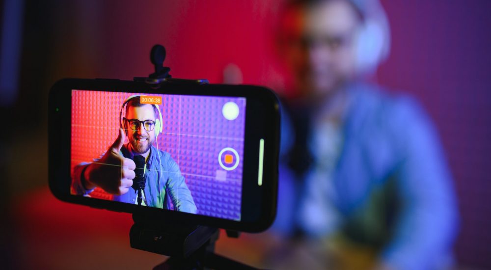 A video blogger records content in his studio. The backstage photo was taken from behind one of the participants in the shooting, at the beginning of the shooting when the blogger is preparing. A video blogger records content in his studio. The backstage photo was taken from behind one of the participants in the shooting, at the beginning of the shooting when the blogger is preparing